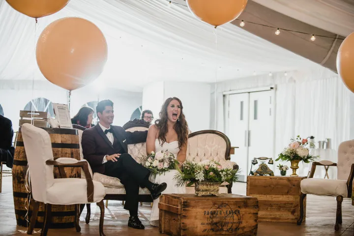 Invités souriants avec accessoires devant la borne photo lors d'un mariage à Lyon